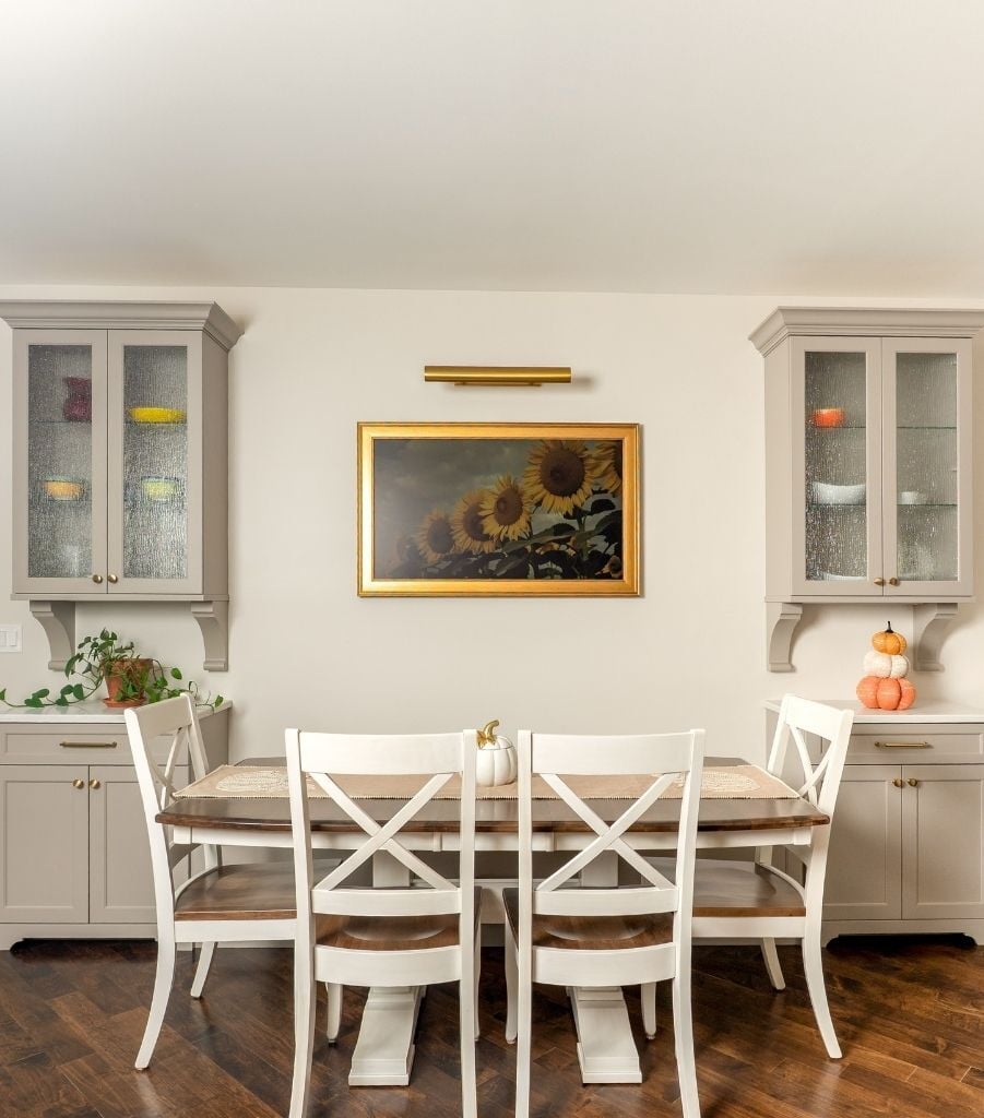 dining area with sunflower painting and built in cabinetry