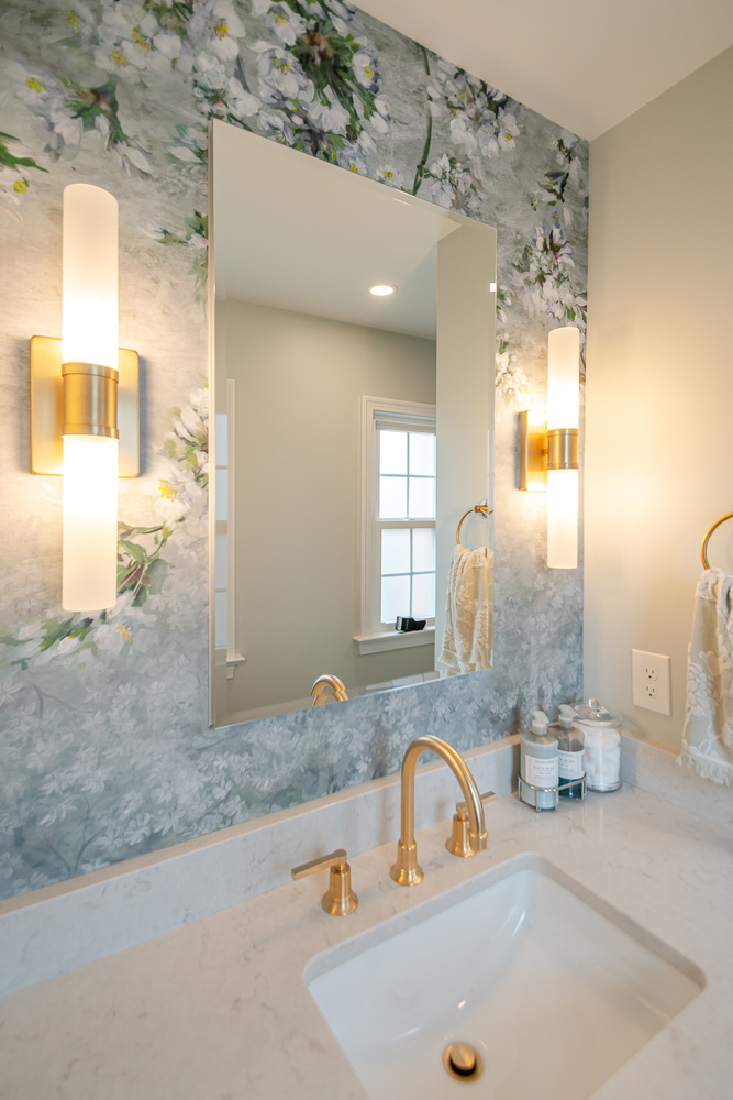 bathroom remodel with floral wallpaper and gold lighting fixtures by Chagrin River Company in University Heights, OH