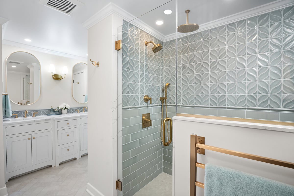 walk-in shower remodel with patterned tile and gold fixtures by Chagrin River Company in Chagrin Falls, OH