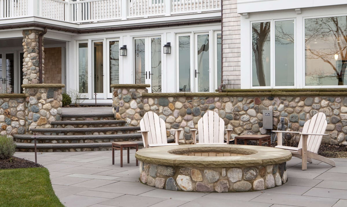 backyard patio with stone fire pit and seating area by Chagrin River Company in Bainbridge, OH