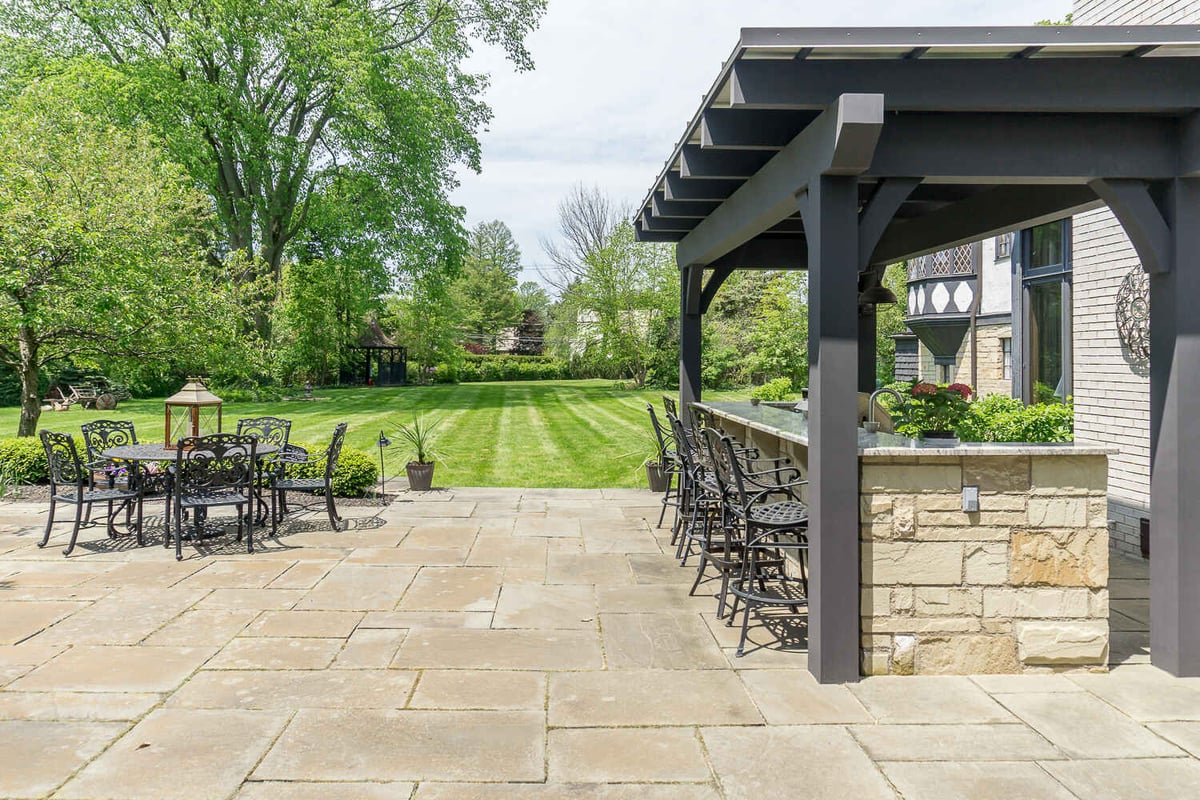exterior renovation featuring patio dining and covered bar area by Chagrin River Company in University Heights, OH
