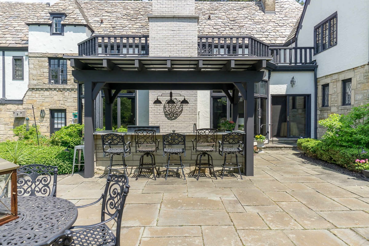 outdoor kitchen bar with granite countertop and seating by Chagrin River Company in Shaker Heights, OH
