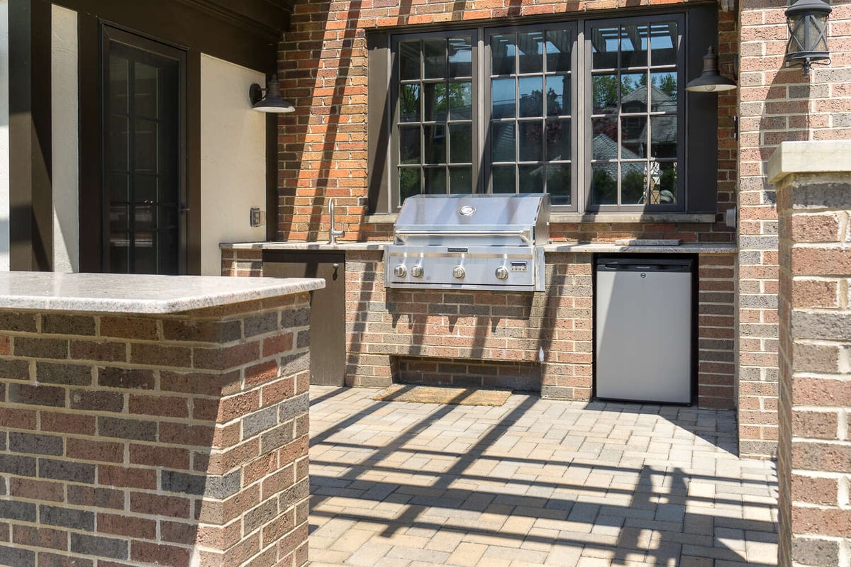 outdoor kitchen patio with built-in grill and brick surround by Chagrin River Company in Shaker Heights, OH