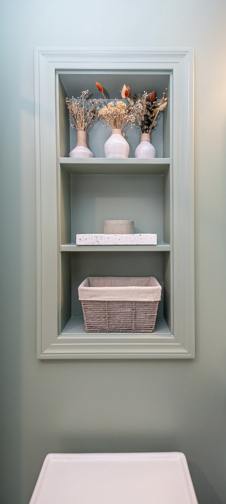 Shaker Heights, OH custom home bathroom built by Chagrin River Company featuring built-in wall shelves and soft green paint.