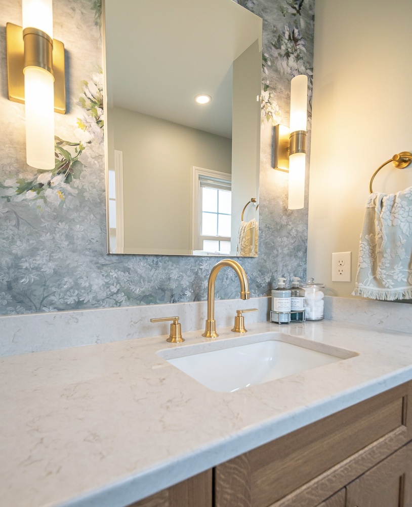 Shaker Heights, OH custom home bathroom built by Chagrin River Company featuring floral accent wall and gold sconces.