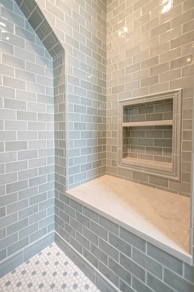 Shaker Heights, OH custom home bathroom built by Chagrin River Company featuring tiled shower walls and marble bench.