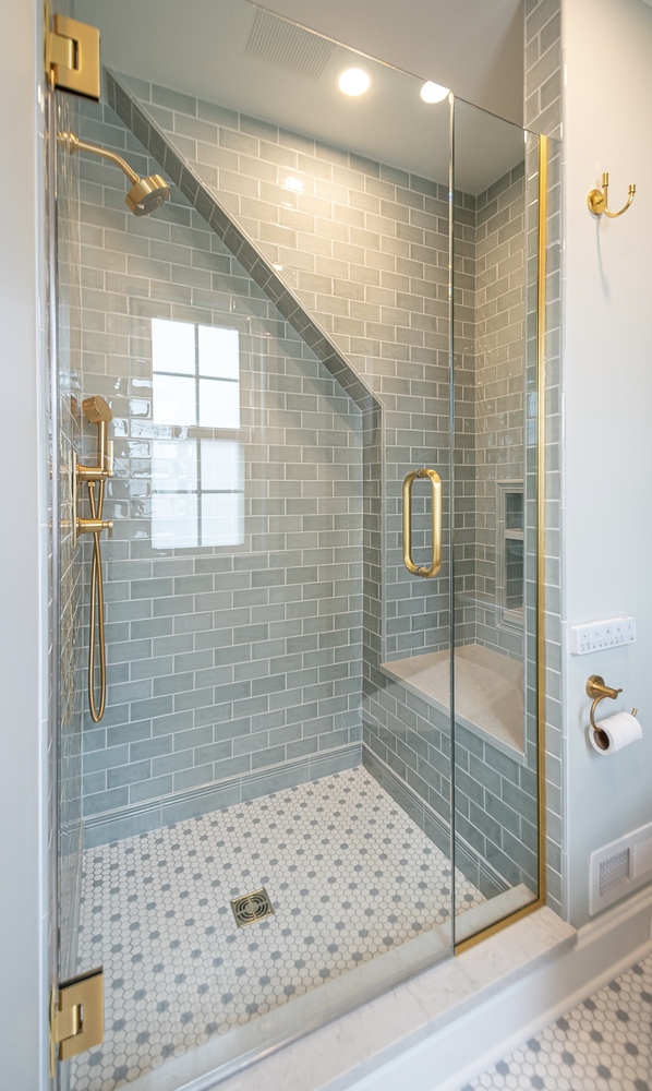 Shaker Heights, OH custom home bathroom built by Chagrin River Company featuring walk-in shower and hex tile flooring.