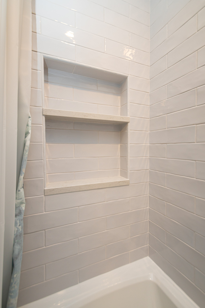 detailed custom home shower tile work by Chagrin River Company in Shaker Heights, OH with classic white tile surround.