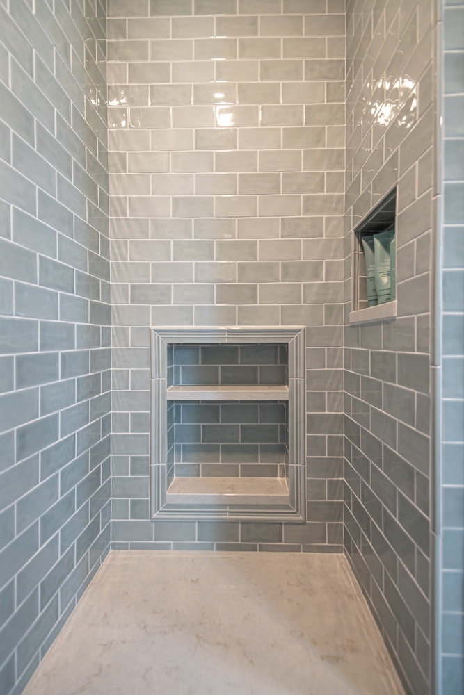 modern custom home shower enclosure by Chagrin River Company in Shaker Heights, OH with marble threshold and brass hardware.