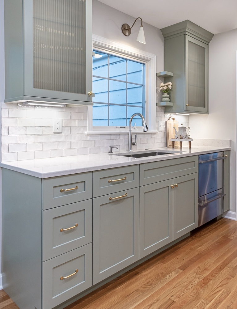 detailed custom home kitchen sink wall by Chagrin River Company in Shaker Heights, OH with brass hardware and modern fixtures.