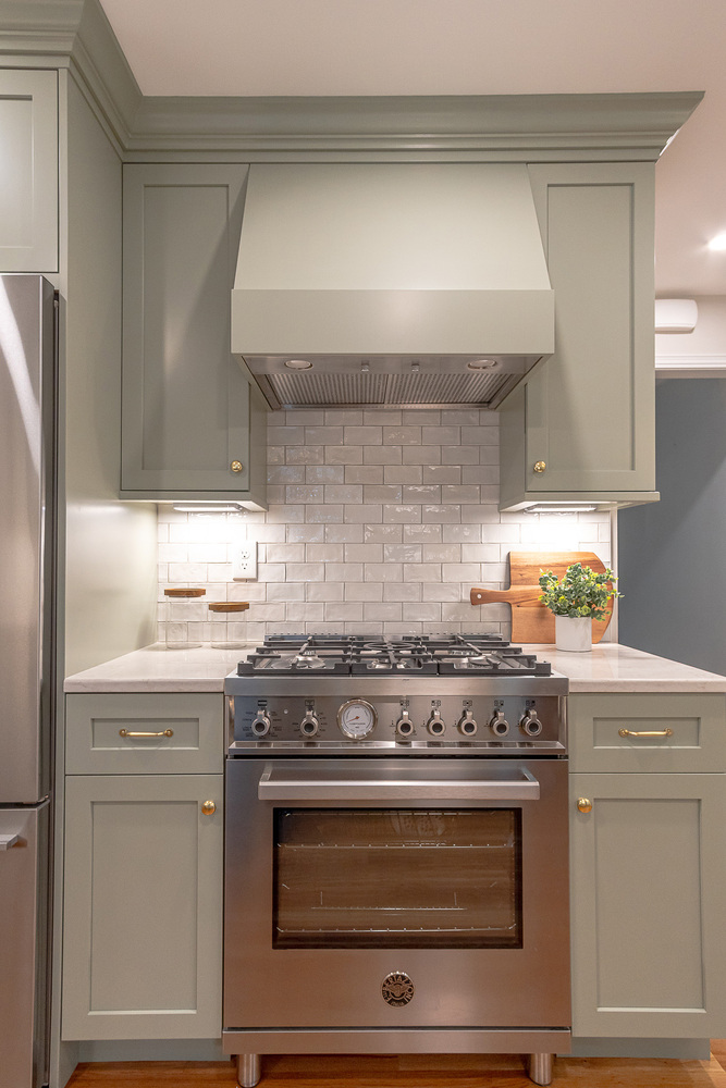 modern custom home kitchen range wall by Chagrin River Company in Shaker Heights, OH with brass hardware and marble counters.