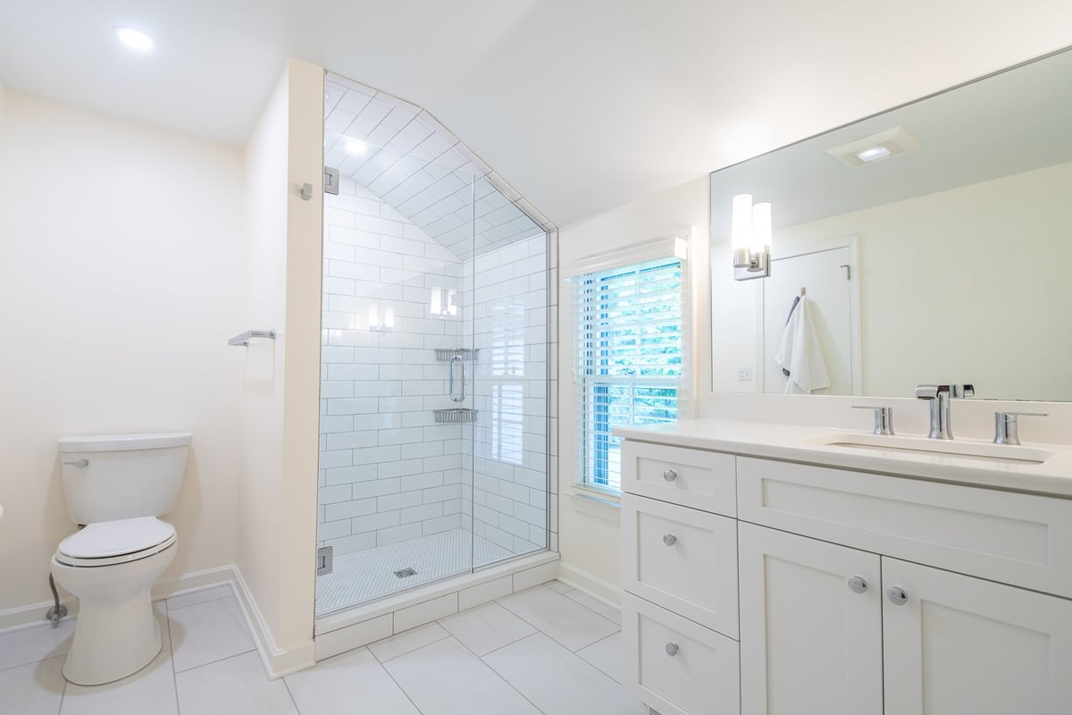 custom home bathroom by Chagrin River Company in Pepper Pike, OH featuring white shaker vanity and glass shower enclosure.