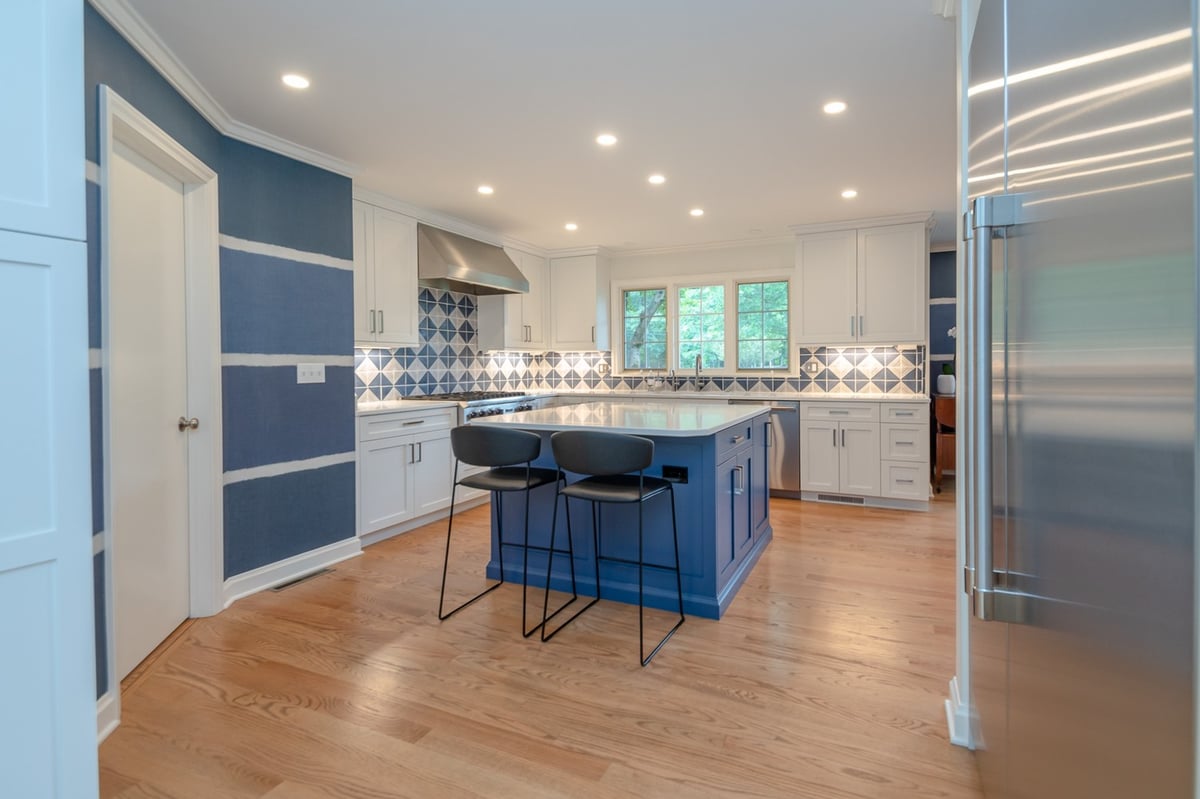 custom home kitchen by Chagrin River Company in Pepper Pike, OH with blue island, white cabinetry, and stainless steel refrigerator.