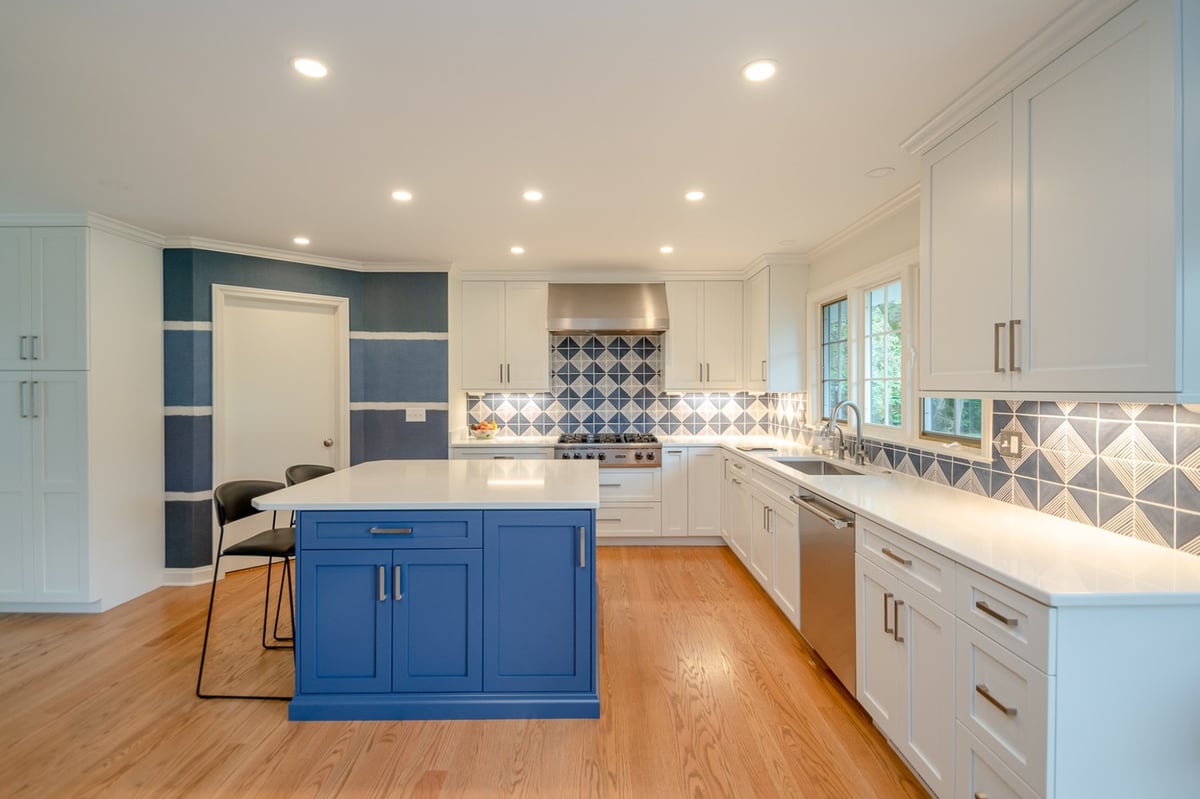 custom home kitchen by Chagrin River Company in Pepper Pike, OH with white cabinetry, blue island, and under-cabinet lighting.