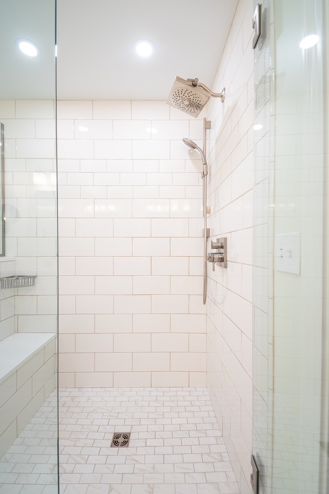 custom home shower interior by Chagrin River Company in Pepper Pike, OH with white subway tile and rainfall showerhead.
