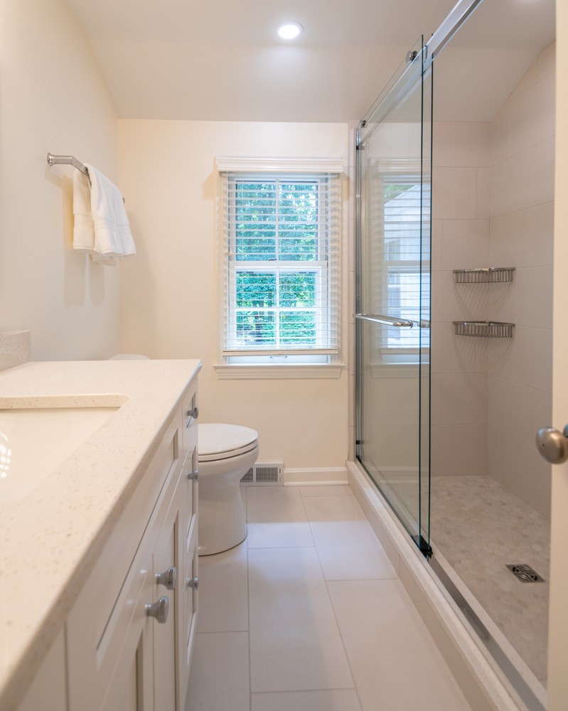 modern custom home walk-in shower in Pepper Pike, OH by Chagrin River Company with built-in shelving and glass enclosure.