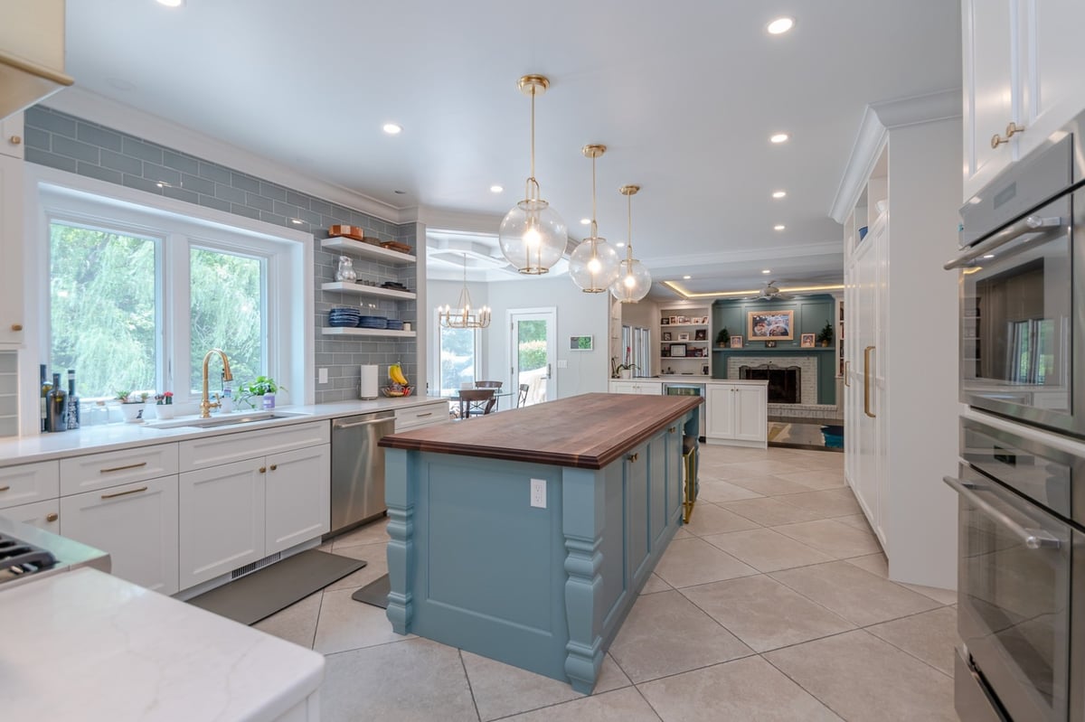custom home kitchen with blue island and globe pendants by Chagrin River Company in Solon, OH