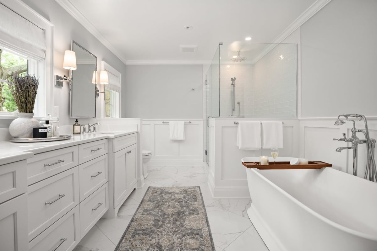 Bright Shaker Heights primary bathroom renovation by Chagrin River Company with a soaking tub, walk-in shower, and white cabinet-optimized