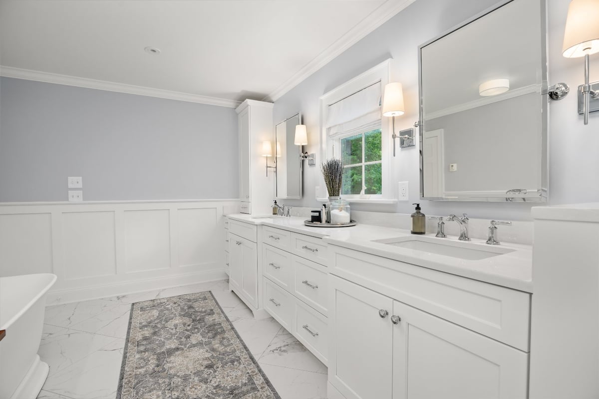 Chagrin River Company bathroom remodel in Shaker Heights featuring a custom double vanity, chrome fixtures, and white cabinetry.-optimized