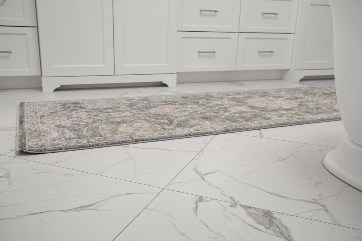 Chagrin River Company bathroom remodel in Shaker Heights featuring marble-look floor tile, white cabinetry, and a patterned runn-optimized