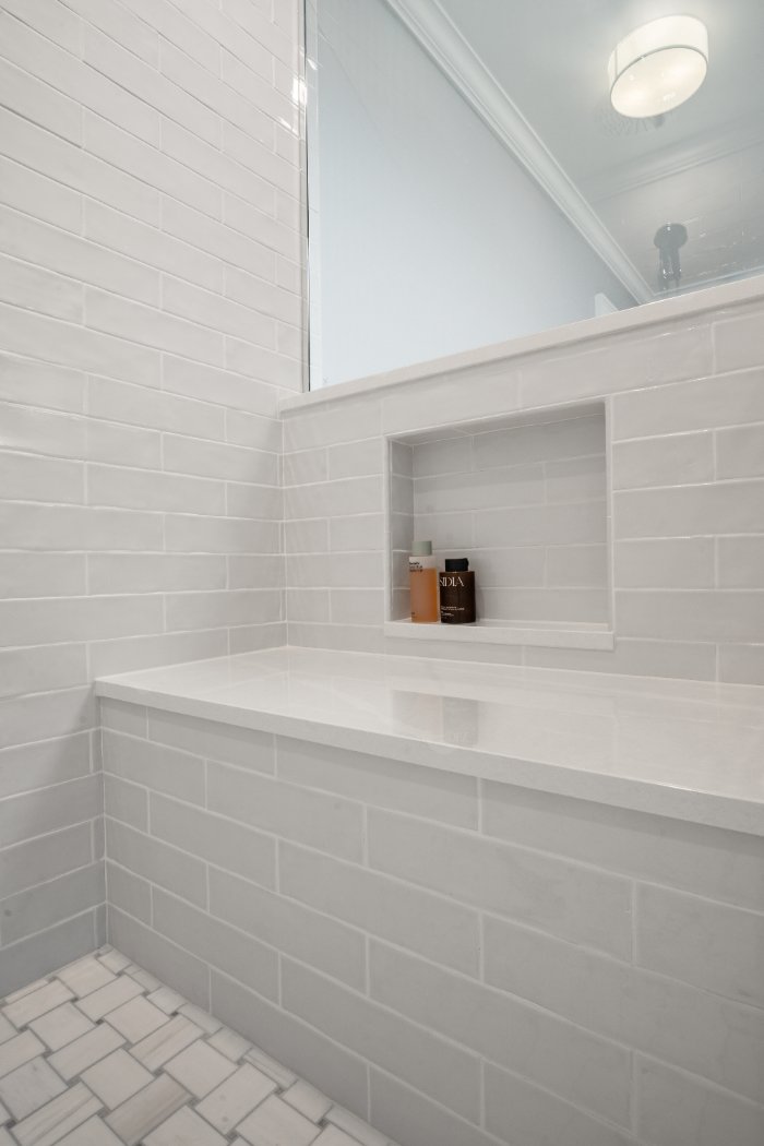 Chagrin River Company bathroom remodel in Shaker Heights featuring white subway tile, a shower niche, glass enclosure, and built-optimized