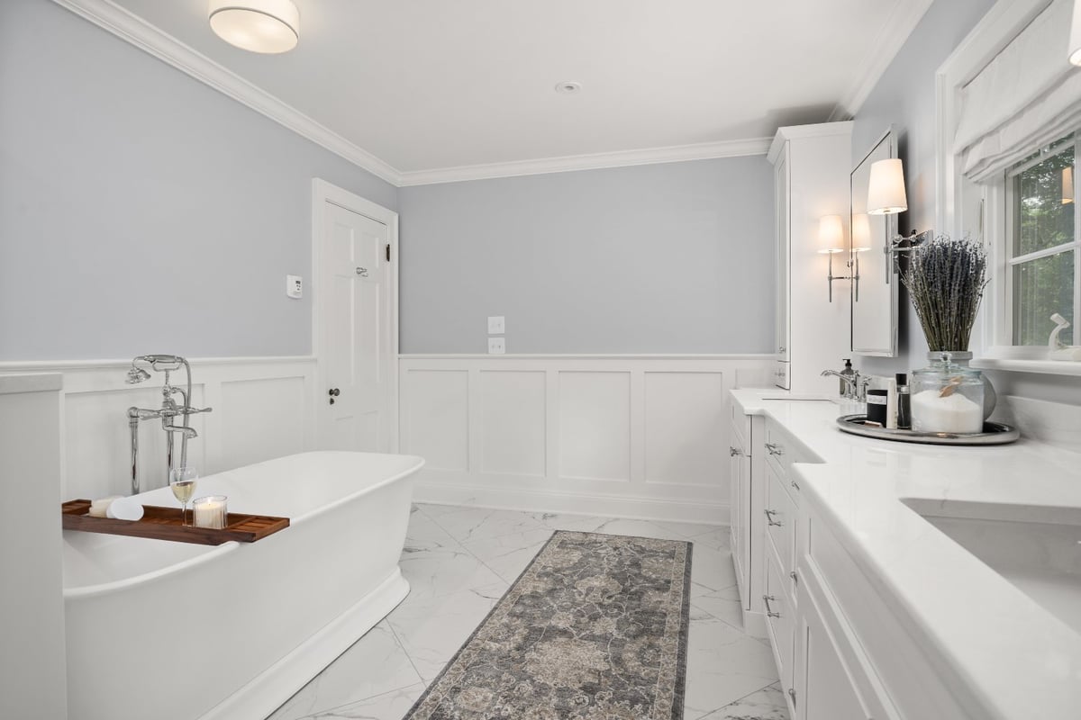 Chagrin River Company bathroom remodel in Shaker Heights with freestanding tub, white vanity, and paneled wainscoting.-optimized
