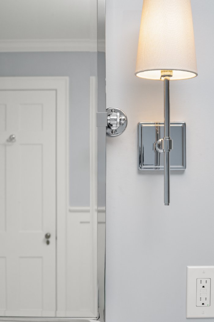 Chrome vanity sconce and framed mirror detail in a Shaker Heights bathroom remodeled by Chagrin River Company.-optimized