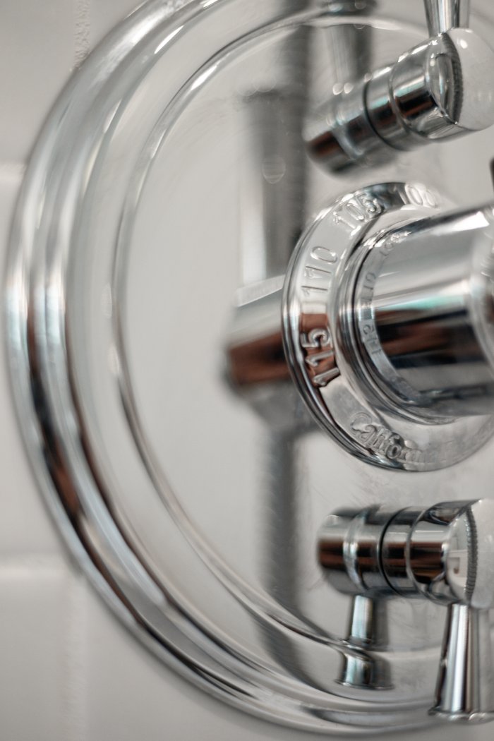 Close-up of polished chrome shower hardware in a Shaker Heights bathroom remodeled by Chagrin River Company.-optimized
