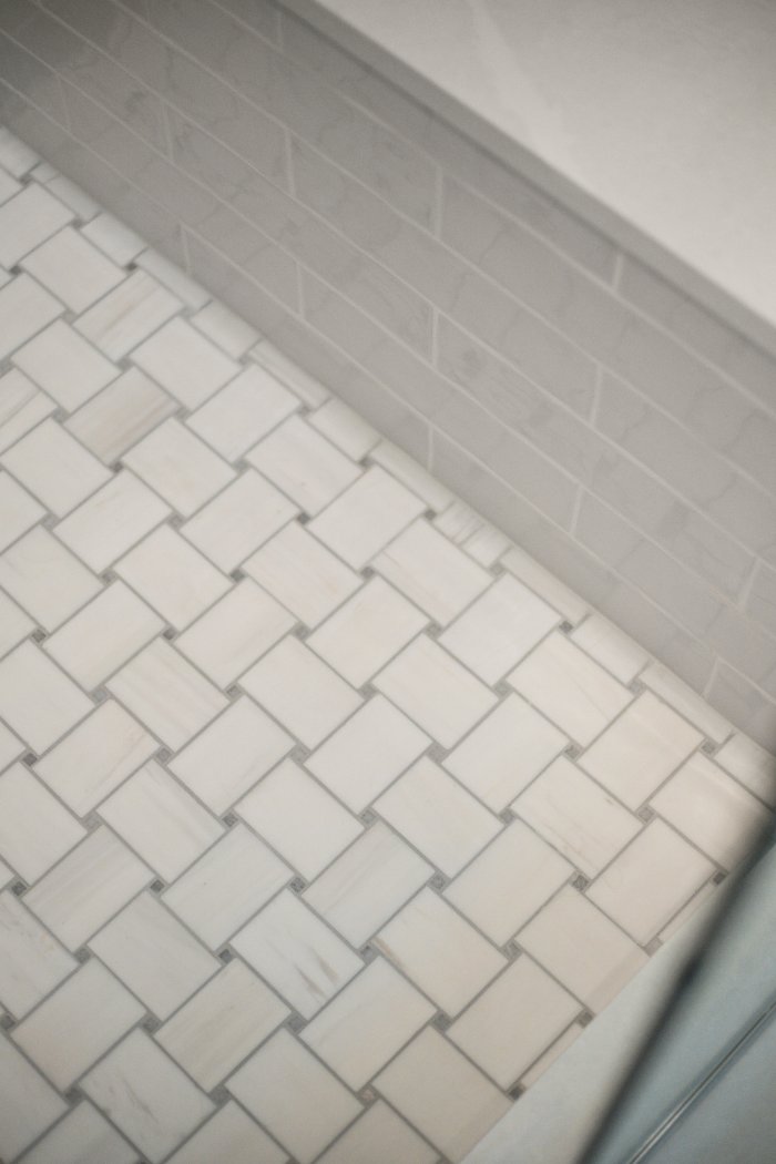 Detailed white shower floor and subway wall tile installation by Chagrin River Company in Shaker Heights.-optimized