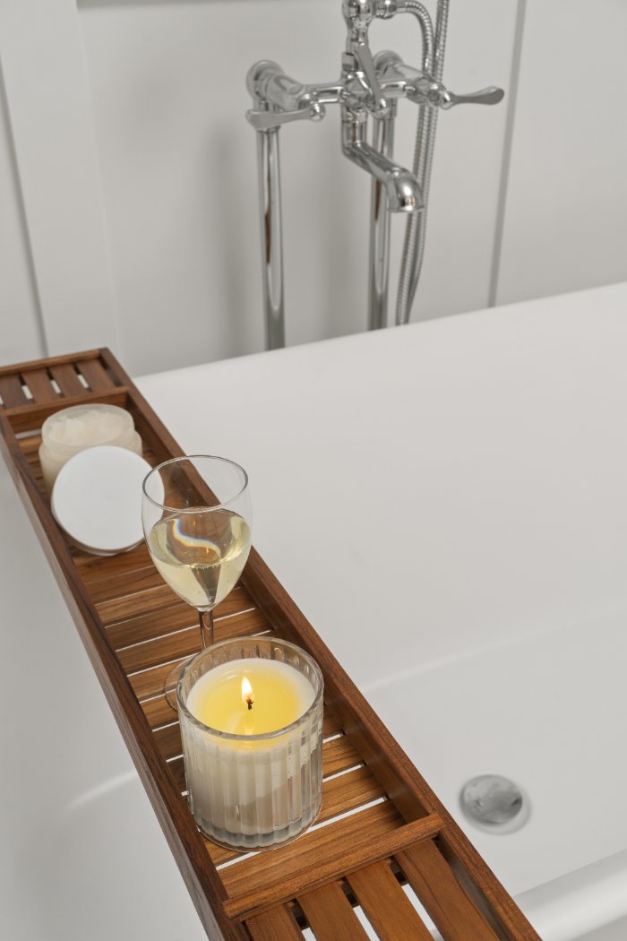 Freestanding white bathtub with a candle, wine glass, and chrome tub filler by Chagrin River Company in Shaker Heights.-optimized