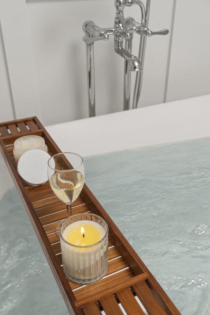 Relaxing freestanding bathtub with water, candle, and wine glass in a Shaker Heights bathroom by Chagrin River Company.-optimized