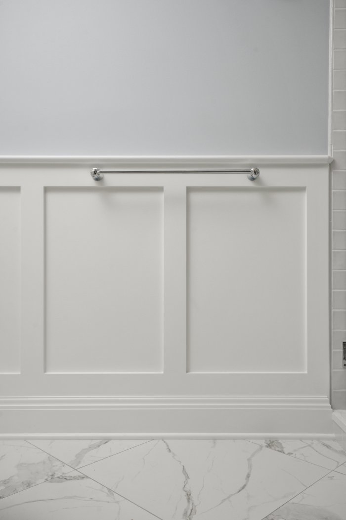 Shaker Heights bathroom detail by Chagrin River Company featuring crisp white wall paneling and a classic chrome towel bar.-optimized