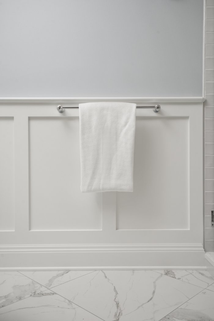 White towel displayed on custom wall paneling in a Shaker Heights bathroom remodeled by Chagrin River Company.-optimized