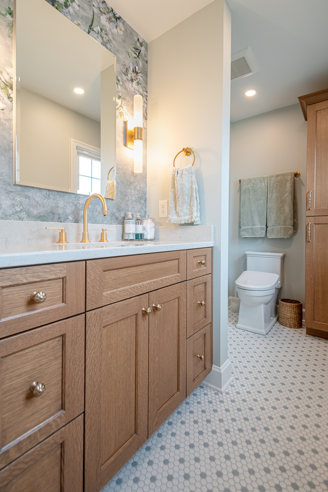 bathroom remodel with wood vanity and floral wallpaper accent by Chagrin River Company in Beachwood, OH