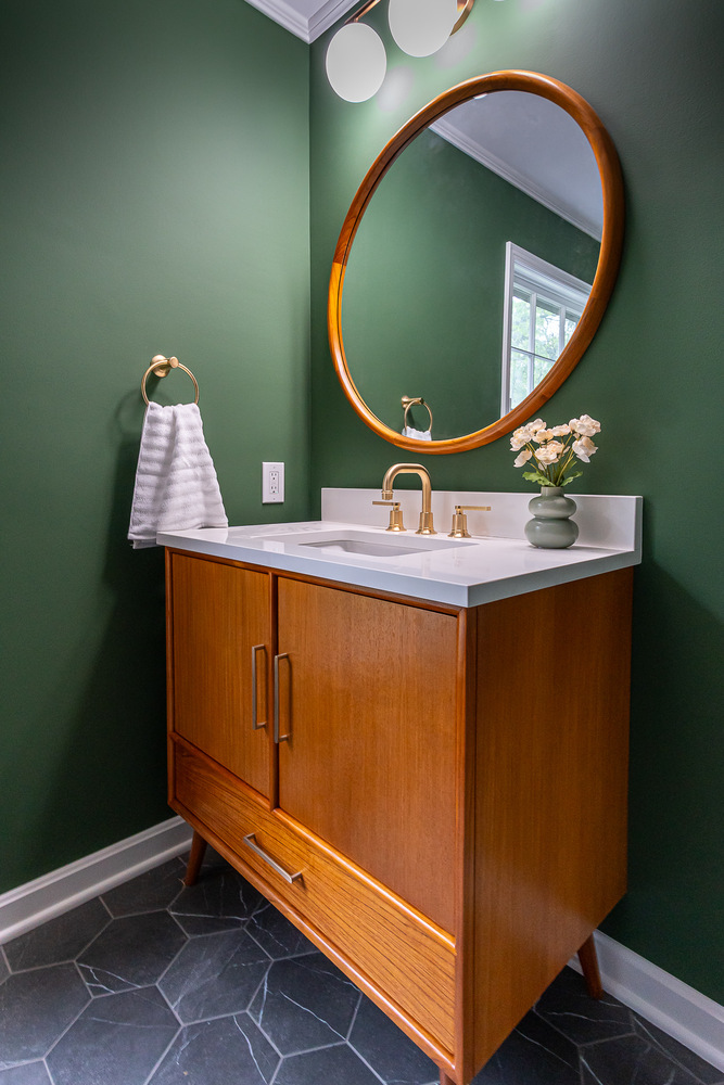 bathroom remodel with wood vanity and round mirror by Chagrin River Company in Willoughby, OH
