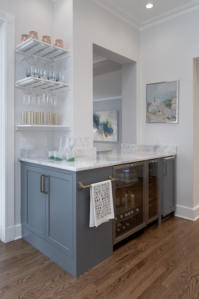built-in bar with gray cabinetry, marble countertop, and wine fridge by Chagrin River Company in Shaker Heights, OH