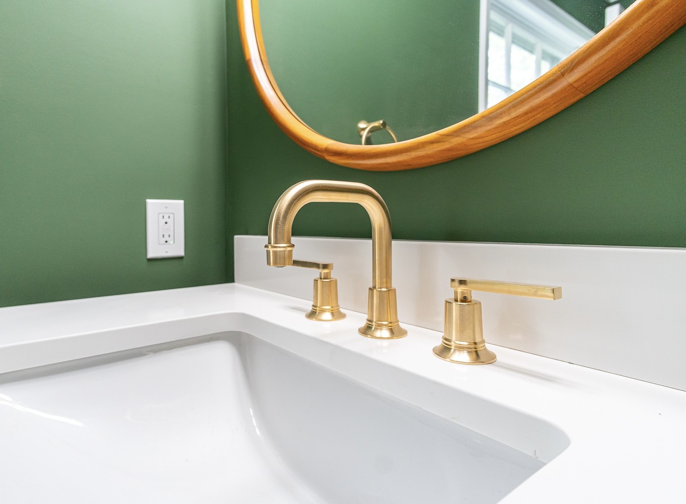 detailed custom home powder room vanity by Chagrin River Company in Shaker Heights, OH with round mirror and brass fixtures.