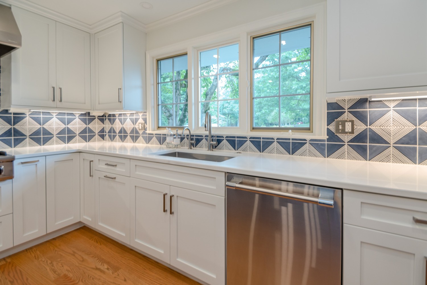 custom home kitchen by Chagrin River Company in Pepper Pike, OH with blue accent wall and white cabinetry.